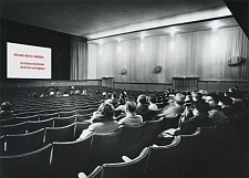 Die Abbildung zeigt eine Fotomontage und zeigt einen historischen Kinosaal mit einer hinzugefügten Ankündigung auf einen Film zur Geschichte des Staatsarchivs Bremen.