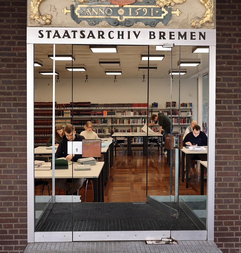 Die Abbildung zeigt den Eingangsbereich des Staatsarchiv Bremen mit Blick in den Lesesaal. Es handelt sich um ein montiertes Bild.
